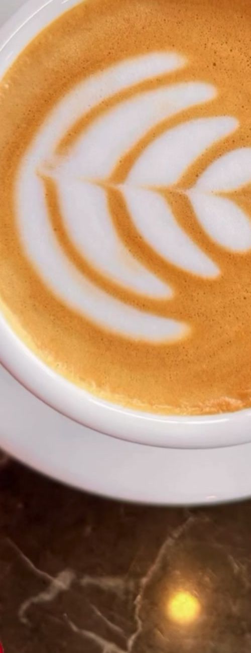 Cappuccino con latte art visto desde arriba sobre mármol