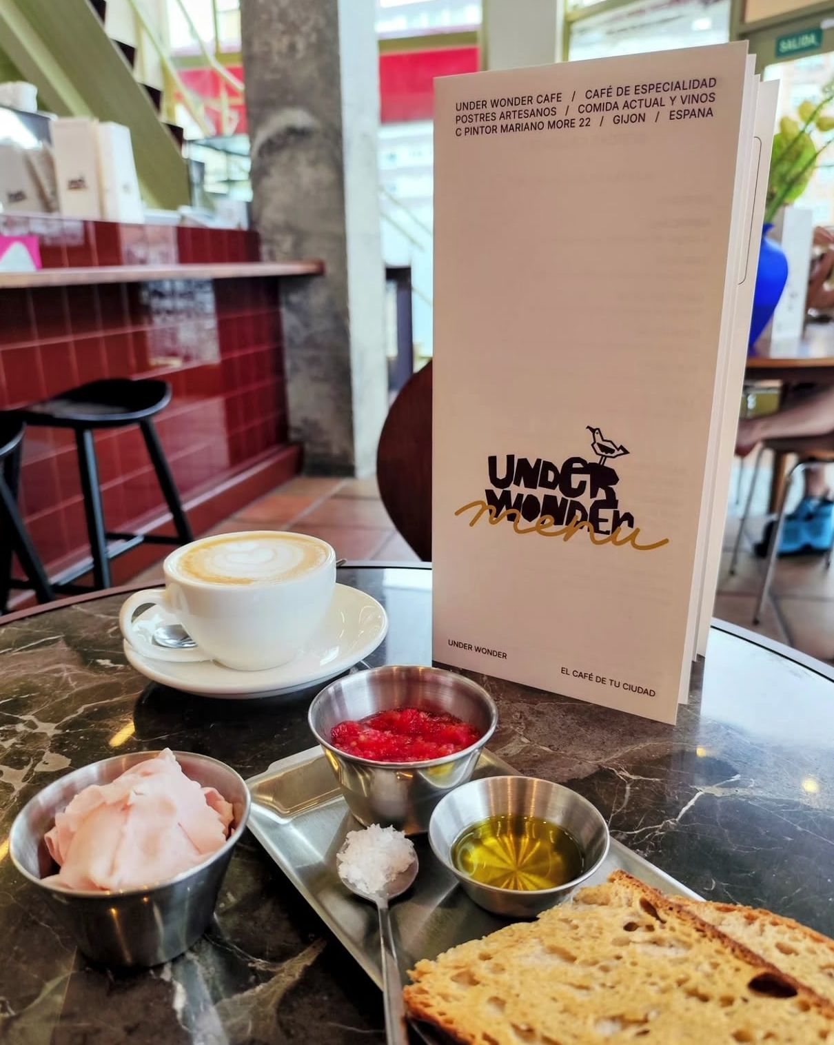 Carta del café junto a bandejas de brunch en la barra roja