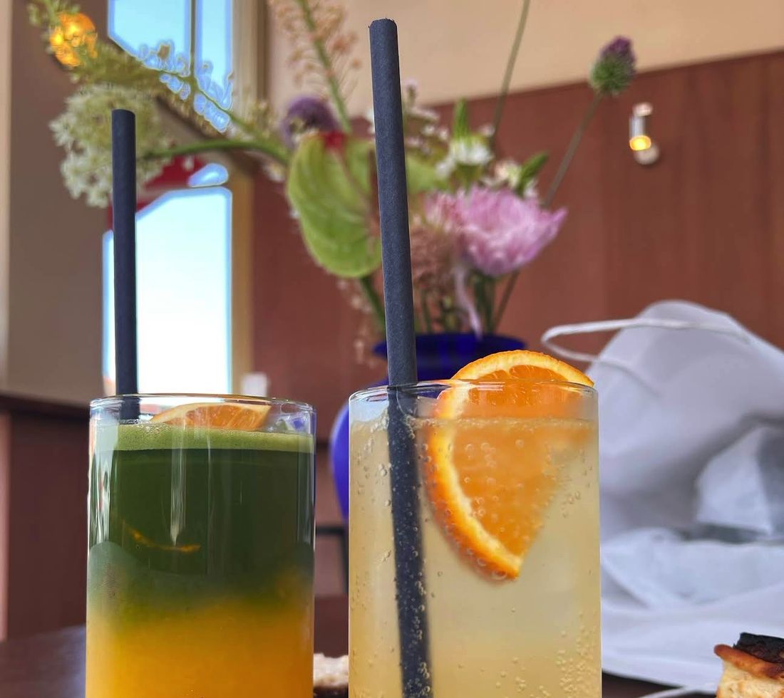 Dos vasos altos: matcha orange y zumo fresco con pajita