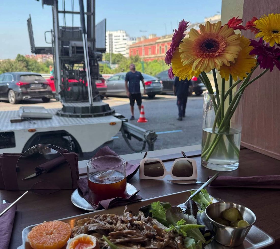 Mesa junto a la ventana con flores, dulces y bandejas de brunch